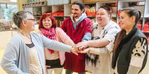 Ehrenamtliche stehen f&uuml;r die Fotoaktion der Tafel- Deutschland gegen Rassismus nebeneinander und legen jeweils eine Hand zu einem Turm &uuml;bereinander
